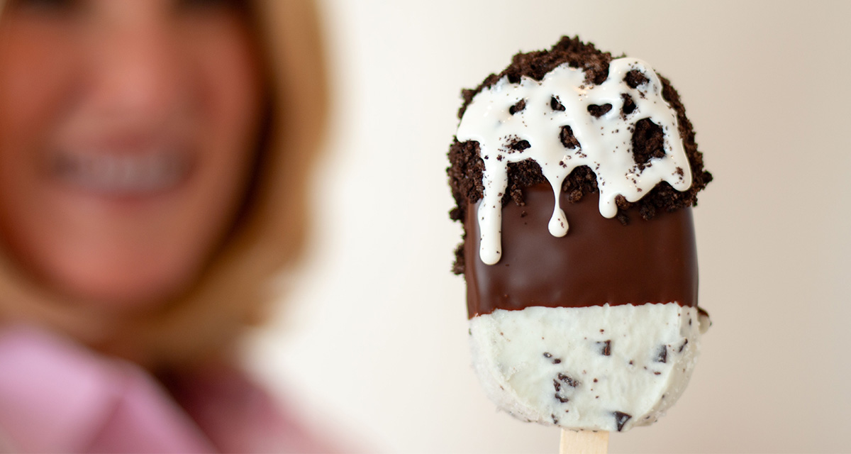 cookies and cream ice cream bar dipped in chocolate and covered with oreo cookie and marshmallow drizzle